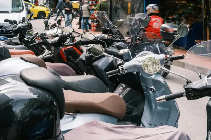 Persona joven eligiendo una scooter de alquiler en una flota